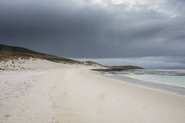 UK, Falklandinseln, Bewölkter Himmel über dem Sandstrand von Carcass Island - RUNF03618