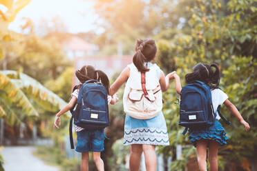 Rear View Of Girls Walking Against Plants - EYF06893