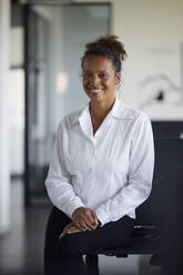 Portrait of smiling businesswoman in modern office - RBF07746