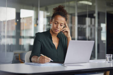 Portrait of pensive businesswoman working at desk - RBF07778