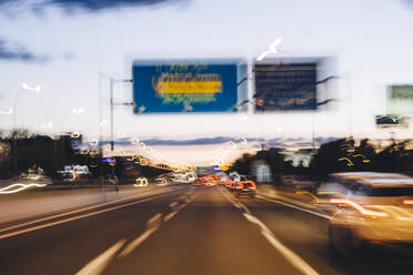 Spanien, Provinz Barcelona, Barcelona, Verkehr auf der Stadtautobahn in der Abenddämmerung - OCMF01366