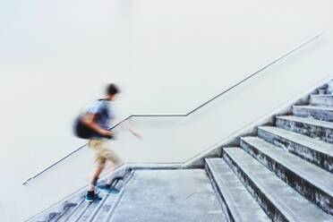 Unscharfe Bewegung eines Mannes, der eine Treppe hinaufgeht - EYF06909