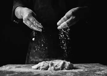 Midsection of Chefkoch Vorbereitung von Lebensmitteln gegen schwarzen Hintergrund - EYF07010