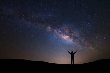 Silhouette Man With Arms Raised Standing Against Star Field At Night - EYF07045