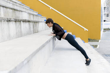 Sportliche Frau beim Plankentraining auf der Treppe - LVVF00059
