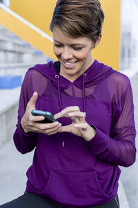 Sportliche Frau mit Smartphone - LVVF00088
