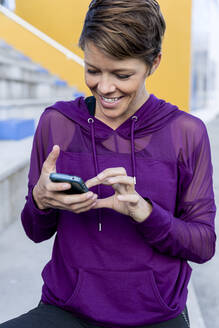 Athletic woman using smartphone - LVVF00088