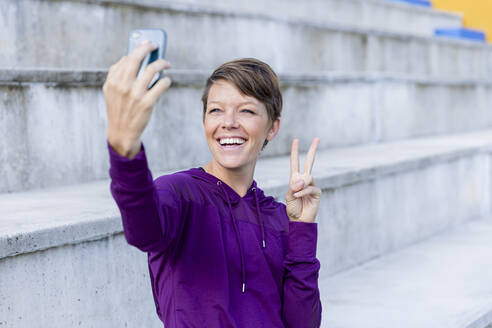 Sportliche Frau, die ein Smartphone benutzt und ein Selfie macht - LVVF00091