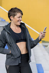 Athletic woman using smartphone and taking a selfie - LVVF00098