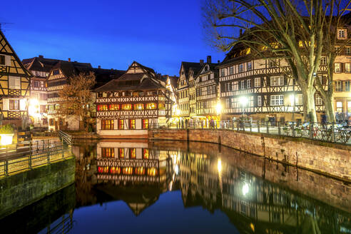 Frankreich, Grand Est, Straßburg, Fachwerkhäuser spiegeln sich im Altstadtkanal in der Abenddämmerung - PUF01931