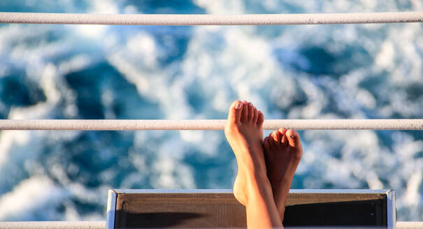 Niedriger Ausschnitt einer Frau, die sich auf einem Boot entspannt - EYF07109