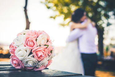 Nahaufnahme von Rose Bouquet mit Paar im Hintergrund - EYF07135