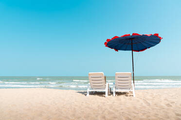 Sunshade And Lounge Chairs On Beach Against Clear Blue Sky - EYF07159