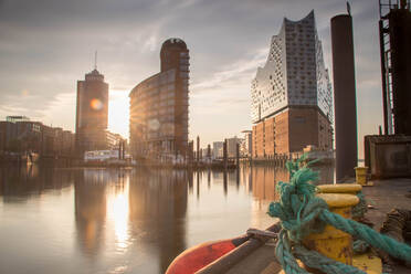 Seil auf Klampe am Hafen gegen Gebäude während Sonnenuntergang gebunden - EYF07163