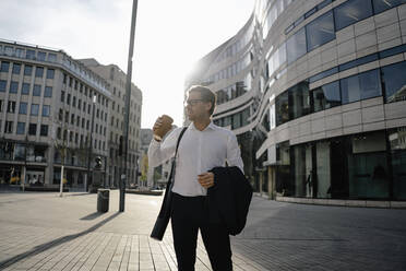Businessman with takeaway coffee in the city - JOSEF00810
