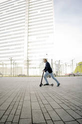 Geschäftsmann fährt Kick-Scooter auf Stadtplatz - JOSEF00869