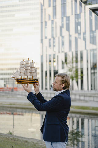 Geschäftsmann mit Modellschiff in der Stadt, lizenzfreies Stockfoto