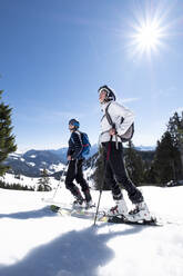 Mother and son skiing on snow covered mountain against sky, Berchtesgaden, Bavaria, Germany - HAMF00640