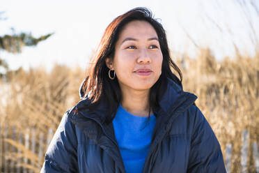 Closeup Porträt der asiatischen Frau im Freien lächelnd am Strand - CAVF85525