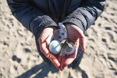 Nahaufnahme von Händen, die Plastikmüll am Strand halten - CAVF85529