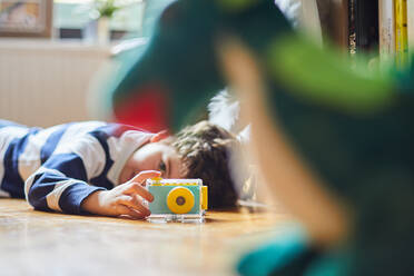 Ein Junge fotografiert seine Spielsachen mit seiner Kamera - CAVF85547