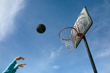 Basketball in air against blue sky - CAVF85585