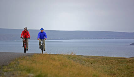 Zwei Freunde fahren mit ihren Mountainbikes um den Thingvellir-See - CAVF85707