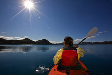 Woman rowing sea kayak on still lake in central Iceland - CAVF85726