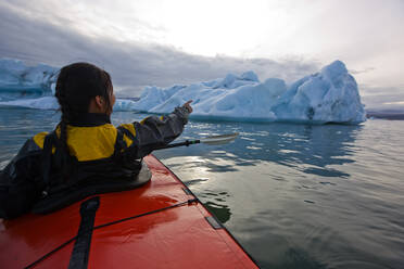 Frau rudert Seekajak auf der Gletscherlagune Jökulsárlón in Island - CAVF85730