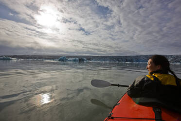 Frau rudert Seekajak auf der Gletscherlagune Jökulsárlón in Island - CAVF85732