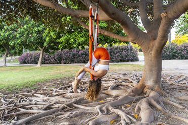 Ältere Frau übt Luft-Yoga auf Seide im Park - DLTSF00765