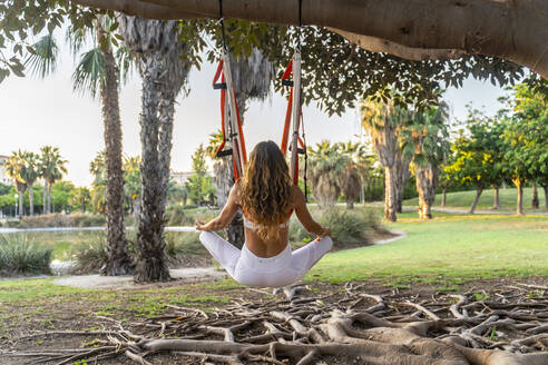 Ältere Frau meditiert beim Yoga in der Luft im Park - DLTSF00773