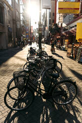 Japan, Präfektur Osaka, Osaka, Sonnenuntergang über Fahrrädern in der Straße Dotonbori - EHF00349