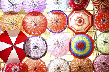 Iran, Fars Province, Shiraz, Colorful umbrellas hanging over bazaar - DSGF02174