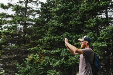 Mann fotografiert beim Wandern im Wald - JVSF00022