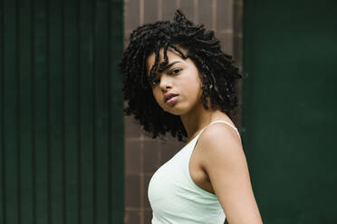 Young beautiful woman with black curly hair standing outdoor - XLGF00225