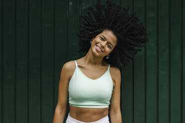 Body positive woman looking at the camera as she confidently embraces her  body, expressing self-love. Plus-size woman with curves and an athletic  physique stands in a studio wearing fitness clothing. stock photo