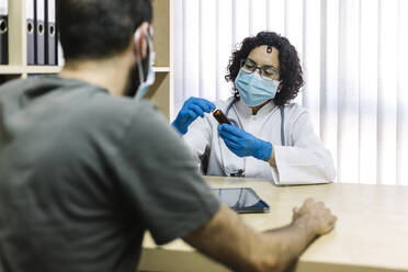 Weiblicher Arzt bespricht Medizin mit Patientin im Büro in der Klinik - XLGF00260