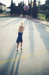 Teenage player taking shot at scoring basketball on court - GIOF08427