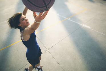 Teenager-Mädchen springt beim Üben von Basketball auf dem Platz - GIOF08429