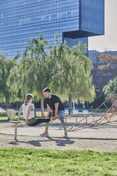 Frau beim Workout mit Trainer im Park - JNDF00181