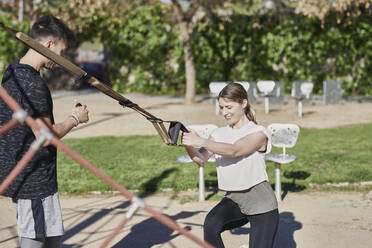 Woman during work out with coach in park - JNDF00184