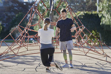 Frau beim Workout mit Trainer im Park - JNDF00185