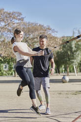 Frau beim Workout mit Trainer im Park - JNDF00186