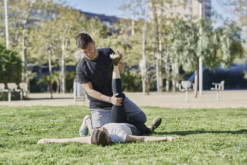 Frau beim Workout mit Trainer im Park - JNDF00188