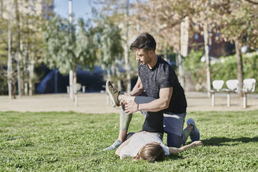 Frau beim Workout mit Trainer im Park - JNDF00189