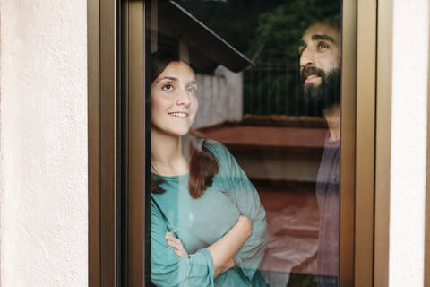 Couple looking out the window and thinking about the future stock photo