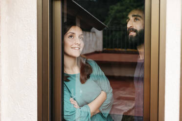 Ein Paar schaut aus dem Fenster und denkt an die Zukunft - JRFF04553
