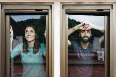 Ein Paar schaut aus dem Fenster und denkt an die Zukunft - JRFF04555