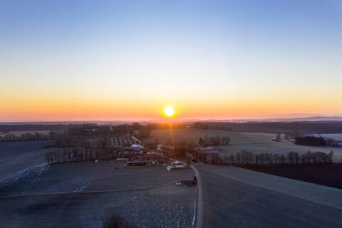 Deutschland, Bayern, Dietramszell, Drohnenansicht eines ländlichen Dorfes bei Sonnenaufgang, lizenzfreies Stockfoto